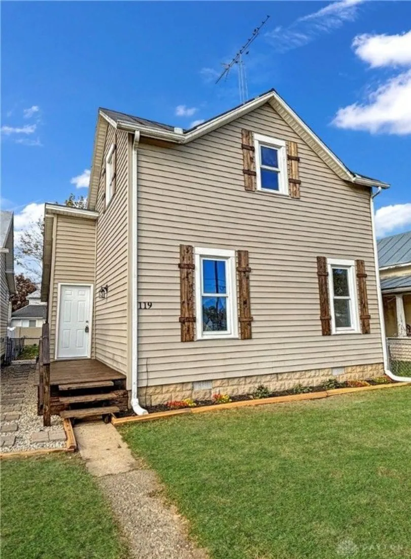 Tan two-story Sycamore house exterior after renovation